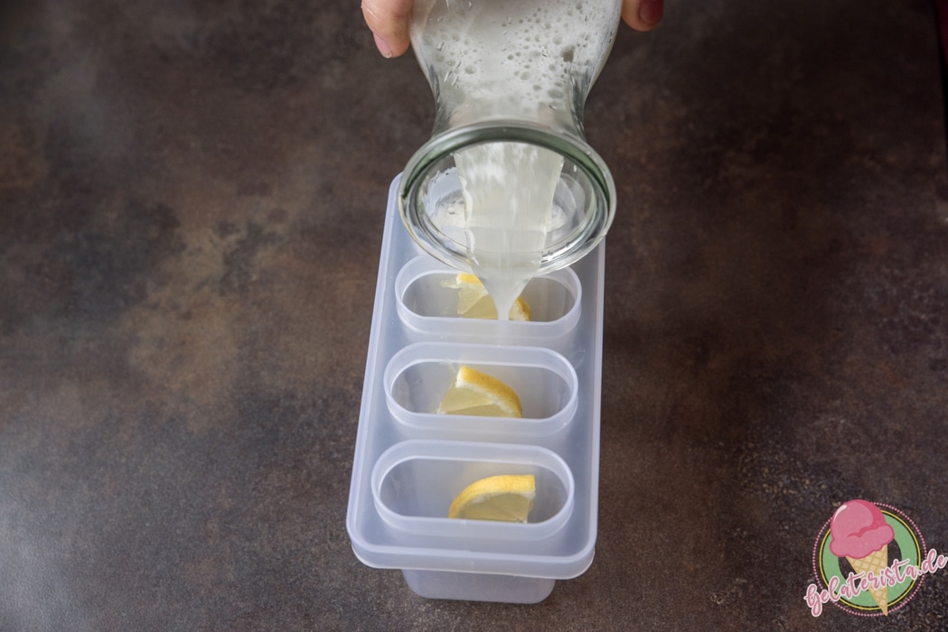 Einfüllen des Zitronenwassers in Eisformen